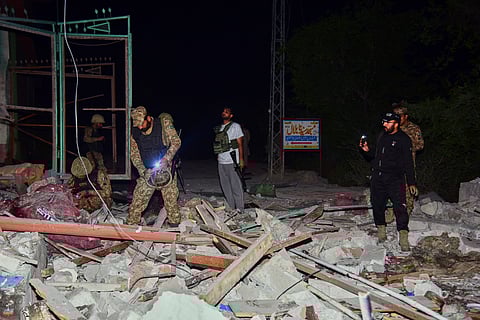 Army soldiers examine a building damaged by a suspected Indian missile attack near Muzaffarabad, the capital of Pakistan controlled Kashmir, Wednesday, May 7, 2025.