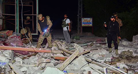 Army soldiers examine a building damaged by a suspected Indian missile attack near Muzaffarabad, the capital of Pakistan controlled Kashmir, Wednesday, May 7, 2025.