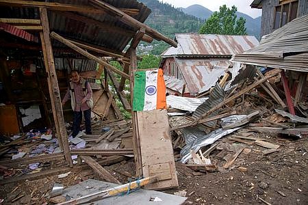 An Indian flag lies in front of a damaged shop following an overnight artillery shelling from Pakistan near the LoC.