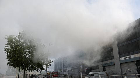A picture taken on May 10, 2025 shows smoke billowing from a building storing pool cleaning products, in the coastal city of Vilanova i la Geltru, south of Barcelona. 