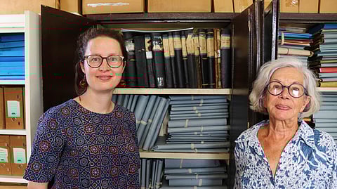 Rosa de Jong, left, and Lilly Duijm pose in front of the boxes of documents from the archive in Paramaribo, Suriname, Friday, May 2, 2025. 