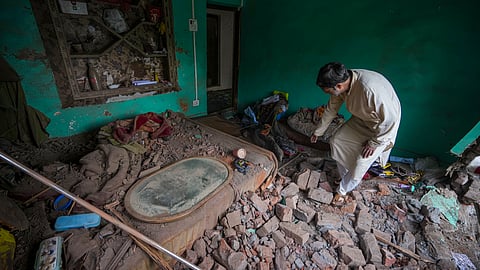A man searches for his belongings amid debris after his house was damaged amid the ongoing military conflict between India and Pakistan, at Uri, in Baramulla district, Jammu and Kashmir, Friday, May 9, 2025