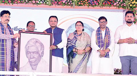 CM Mohan Charan Majhi being presented with a portrait of Pandit Raghunath Murmu