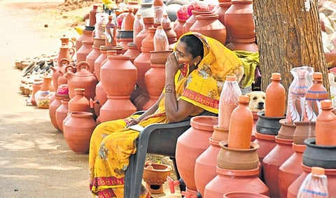 A vendor of earthen pots taking a nap in the afternoon.