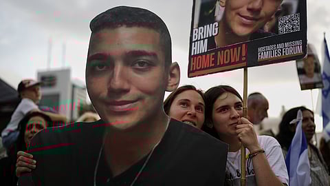 People watch a live broadcast of Israeli-American soldier Edan Alexander as he is released from Hamas captivity in Gaza, at a plaza known as the hostages square in Tel Aviv, Monday, May 12, 2025.