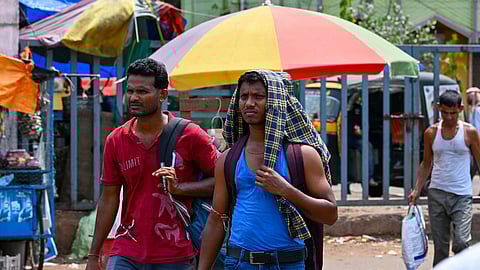 In this file photo, people cover their heads with cloth to shield themselves from the heat near Master Canteen in Bhubaneswar