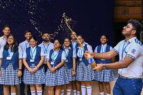 Students celebrate after Class 12 CBSE results are declared, at BJEM School in Bhubaneswar on Tuesday. 