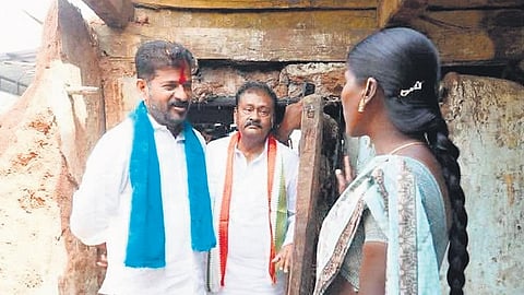 A file picture shows the then TPCC chief and present Chief Minister A Revanth Reddy interacting with Bhikkanoor Laxmi in her dilapidated house in Chinnamallareddy village.