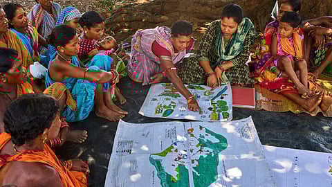 Kamala Kadria, third from right, a woman from the Gadaba Indigenous community, points to a spot on a map they made as others look on in Hatipakna village, Koraput district, in India's eastern state of Odisha, Wednesday, April 16, 2025. 