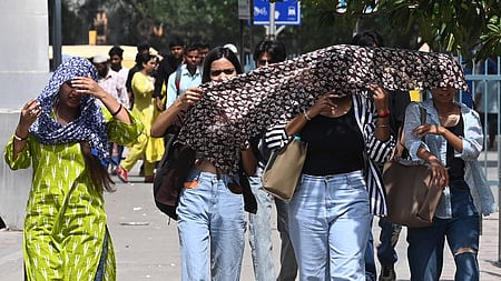 Commuters brave the heat wave during a hot summer afternoon at Sarojini Nagar Market as the temperature rises, on May 18, 2025 in New Delhi.