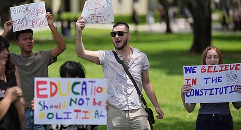 A group of Florida International University students protest against cuts in federal funding and an agreement by campus police to partner with Immigration and Customs Enforcement, on the FIU campus on a day of protests around the country in support of higher education, Thursday, April 17, 2025, in Miami. 