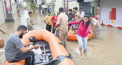 Residents being evacuated from Sai Layout after floodwaters entered their homes following heavy rain on Monday.