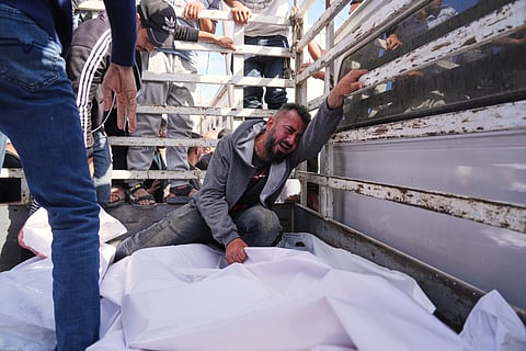 Osama Abu Mosabbah, mourns his wife and two children who were killed in an Israeli army airstrike on the Gaza Strip, during their funeral at Al-Aqsa Hospital in Deir al-Balah, Gaza, Tuesday, May 20, 2025.