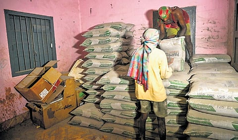 Workers removing cement bags from a government quarter that had been turned into a  godown, near Rajmahal square in Bhubaneswar on Tuesday