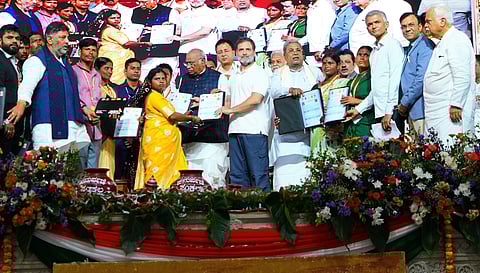 Beneficiaries receive title deeds from the state government at the Samarpane Sankalpa in Hosapete on Tuesday 
