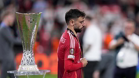 Manchester United's Bruno Fernandes walks past the trophy at the end of the Europa League final soccer match between Tottenham Hotspur and Manchester United at the San Mames Stadium in Bilbao, Spain, Wednesday, May 21, 2025.