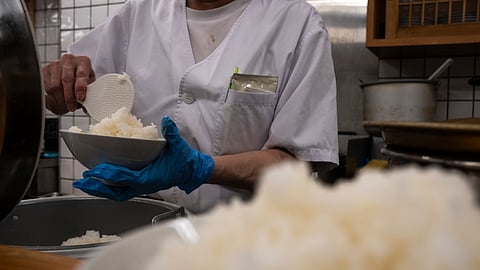 An employee prepares a bowl of rice at a restaurant in Tokyo, Thursday, May 22, 2025. 