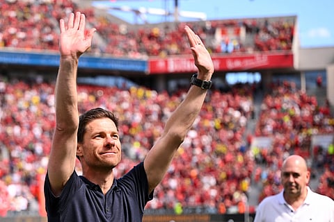 Leverkusen's head coach Xabi Alonso waves to the fans before the German Bundesliga soccer match.