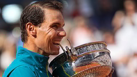 Spain's Rafael Nadal bites the trophy after winning the final match against Norway's Casper Ruud in three sets, 6-3, 6-3, 6-0, at the French Open tennis tournament in Roland Garros stadium in Paris, France, June 5, 2022.