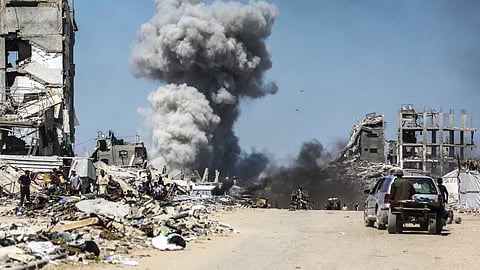 People watch as smoke billows following an Israeli strike in Jabalia, in the northern Gaza Strip, on May 25, 2025.