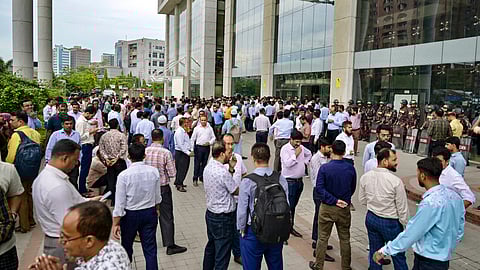 Border Guard Bangladesh (BGB) personnel (back R) stand guard as National Board of Revenue (NBR) employees protest in front of the NBR office in Dhaka on May 25, 2025.