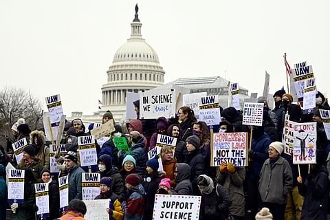 Medical researchers from universities and the National Institutes of Health rally near the Health and Human Services headquarters to protest federal budget cuts.