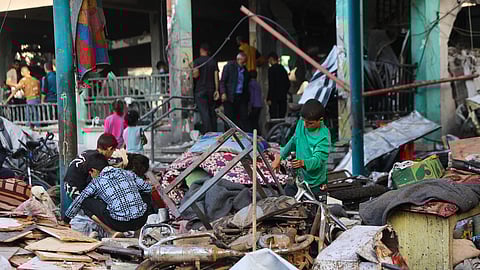 Children sort through belongings amid the debris at the Fahmi Al-Jarjawi School in Gaza City on May 26, 2025, following an Israeli strike.