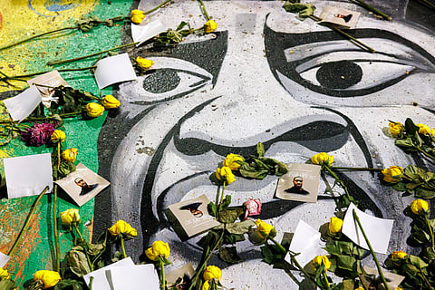 Yellow roses and tribute cards are placed over a street mural of George Floyd at George Floyd Square in Minneapolis, Minnesota, on May 25, 2025, during a commemoration event marking the fifth anniversary of his death.