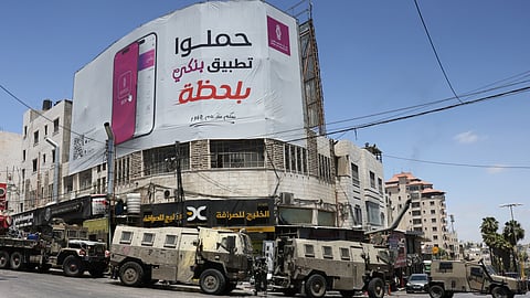 Israeli forces' armoured vehicle block the way to Al-Khaleej (Gulf) Exchange Company in the Palestinian city of Hebron in the occupied southern West Bank on May 27, 2025.