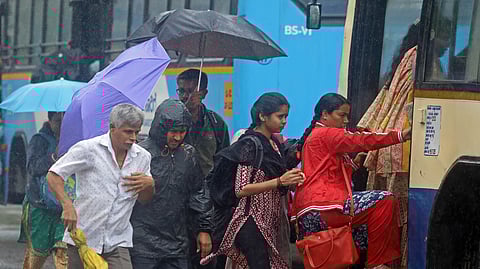 eople witness the morning rain shower as they leave for their work on Kengeri ring road in Bengaluru on Monday.
