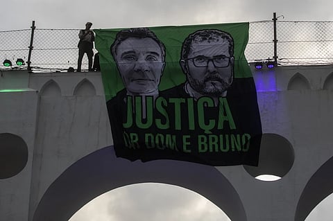 A sign that reads in Portuguese “Justice for Dom and Bruno” with images of the British journalist Dom Phillips, on the left, and the Indigenous specialist Bruno Pereira, is displayed on the Arcos da Lapa aqueduct during a protest by environmental groups to ask for justice for their deaths, in Rio de Janeiro, Brazil, June 26, 2022.
