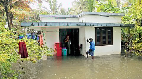 Mini Ratheesh standing in their flooded house at Njarakkal. Several families in the region are struggling with coastal flooding since the onset of monsoon.
