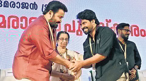 Actor Mohanlal presents the Padmarajan Award to director Fazil Muhammad as Padmarajan’s wife Radha Lakshmi looks on at the ceremony held at Tagore Theatre on Friday.