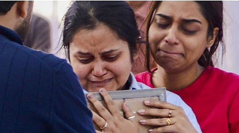 File | Pahalgam terror attack victim Shubham Dwivedi's wife, in blue shirt, and his sister mourn after his mortal remains were brought to his residence, in Kanpur, Thursday, April 24, 2025.