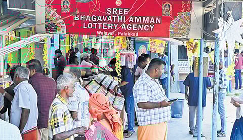 A busy lottery stall at Walayar. (Below) Customers purchasing lottery tickets.