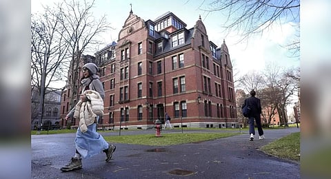 People walk between buildings, Dec. 17, 2024, on the campus of Harvard University in Cambridge, Mass.
