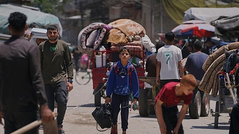 Palestinians fleeing Jabalia move with their belongings on a street in Gaza City, Friday, May 30, 2025.