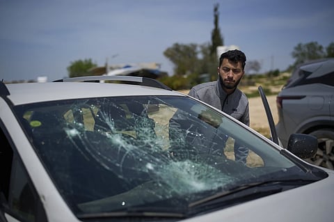Basel Adra, Palestinian co-director of the Oscar winner documentary “No Other Land”, looks at a damaged car after a settler’s attack in the village of Susiya in Masafer Yatta, south Hebron hills, March 25, 2025. 