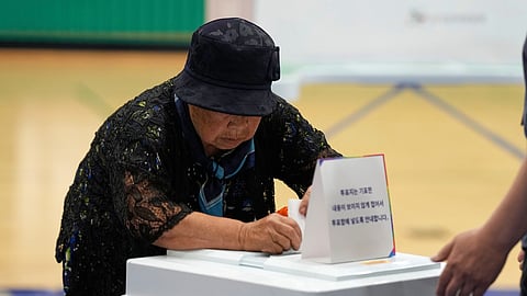 A woman casts her vote for the presidential election at a polling station in Seoul, South Korea, Tuesday, June 3, 2025. (AP Photo/Lee Jin-man)
