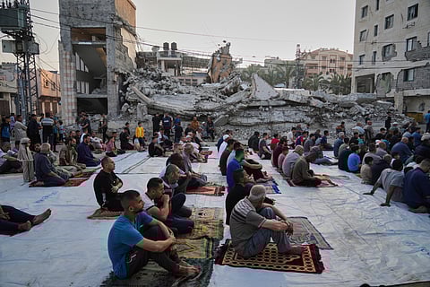 Palestinians gather for Eid al-Adha prayers beside the ruins of a mosque destroyed by Israeli bombardment, in Deir al-Balah, Gaza on Friday, June 6, 2025. 