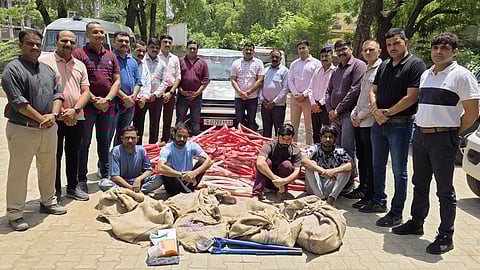 Gujarat police pose with the four arrested and the seized material. 