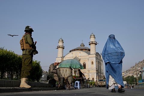 A Taliban fighter stands guard near the Shah-Do Shamshira Mosque as people attend the Eid al-Adha prayer in Kabul, Afghanistan, Saturday, June 7, 2025.