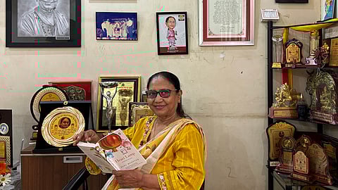This photograph taken on May 31, 2025, shows Indian lawyer, activist and now International Booker Prize winner Banu Mushtaq posing with the book 'Heart Lamp' at her residence in Hassan, Karnataka.