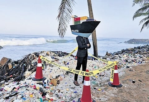 A ship mascot against the backdrop of plastic nurdles at the Valiyathura beach 