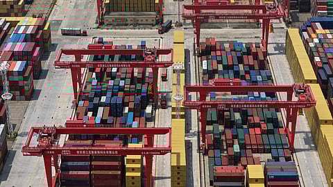 Trucks move through containers piled up at a container terminal in Nanjing in east China's Jiangsu province on June 3, 2025.