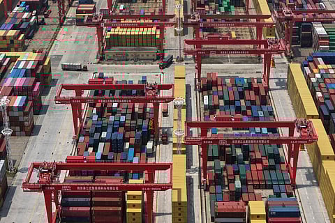 Trucks move through containers piled up at a container terminal in Nanjing in east China's Jiangsu province on June 3, 2025.