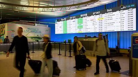 Travelers push their luggage through the international arrivals area at the Los Angeles International Airport in Los Angeles, Saturday, June 8, 2025. 