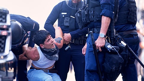 A protester is detained in downtown Los Angeles, Sunday, June 8, 2025, following last night's immigration raid protest.