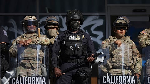 US Customs and Border Protection officers and National Guard soldiers are posted at the entrances of the Federal Building in Los Angeles while protesters rally during a demonstration in response to a series of US Immigration and Customs Enforcement (ICE) raids throughout the country