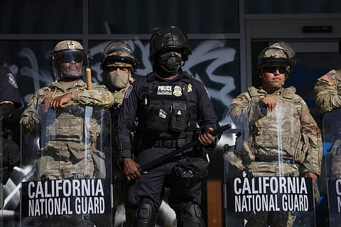 US Customs and Border Protection officers and National Guard soldiers are posted at the entrances of the Federal Building in Los Angeles while protesters rally during a demonstration in response to a series of US Immigration and Customs Enforcement (ICE) raids throughout the country